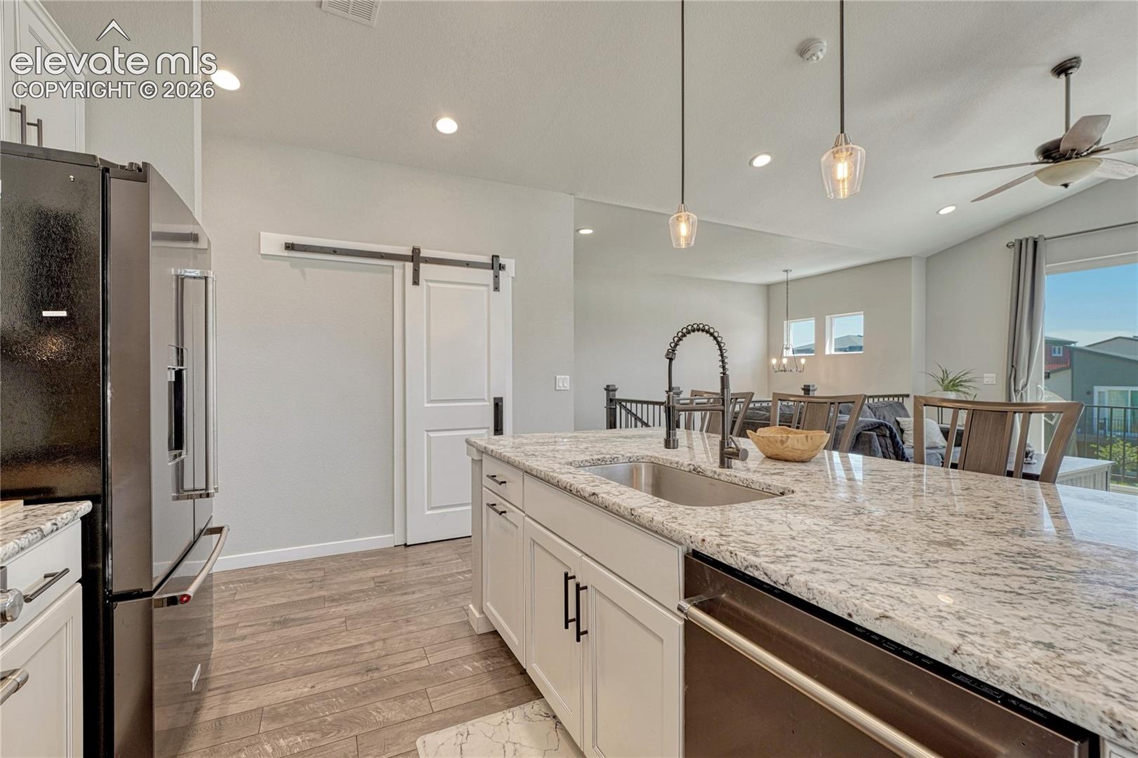 Beautiful slab granite countertops and barn door on pantry. 