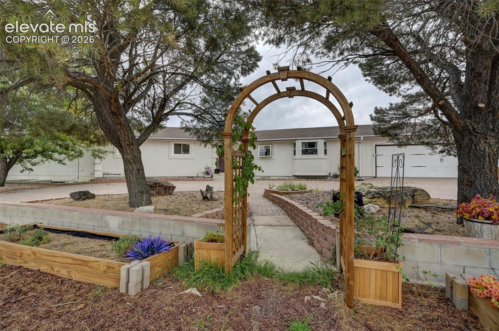 Wood archway entrance to a paved pathway