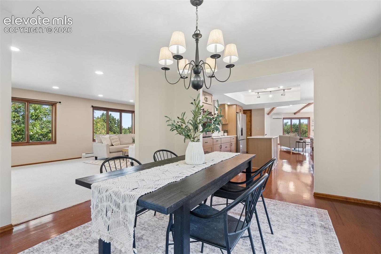 Recessed lighting, wood-finish flooring, and a chandelier with fabric shades
