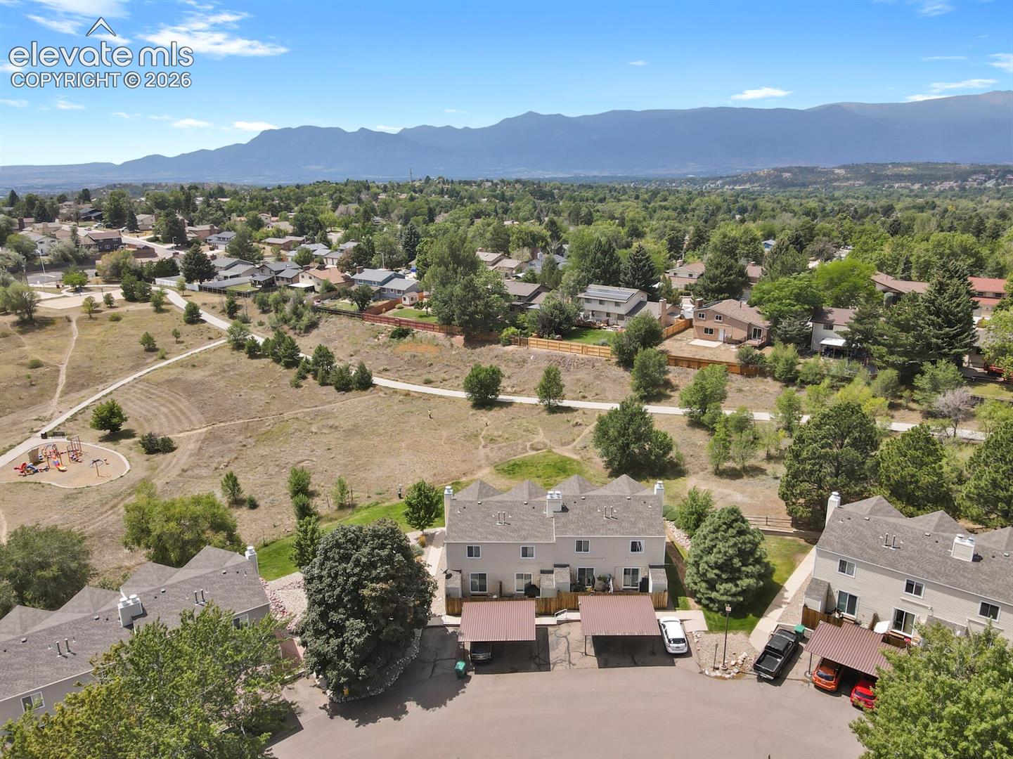 Townhome community with mountain scenery, multiple carports, and nearby park space