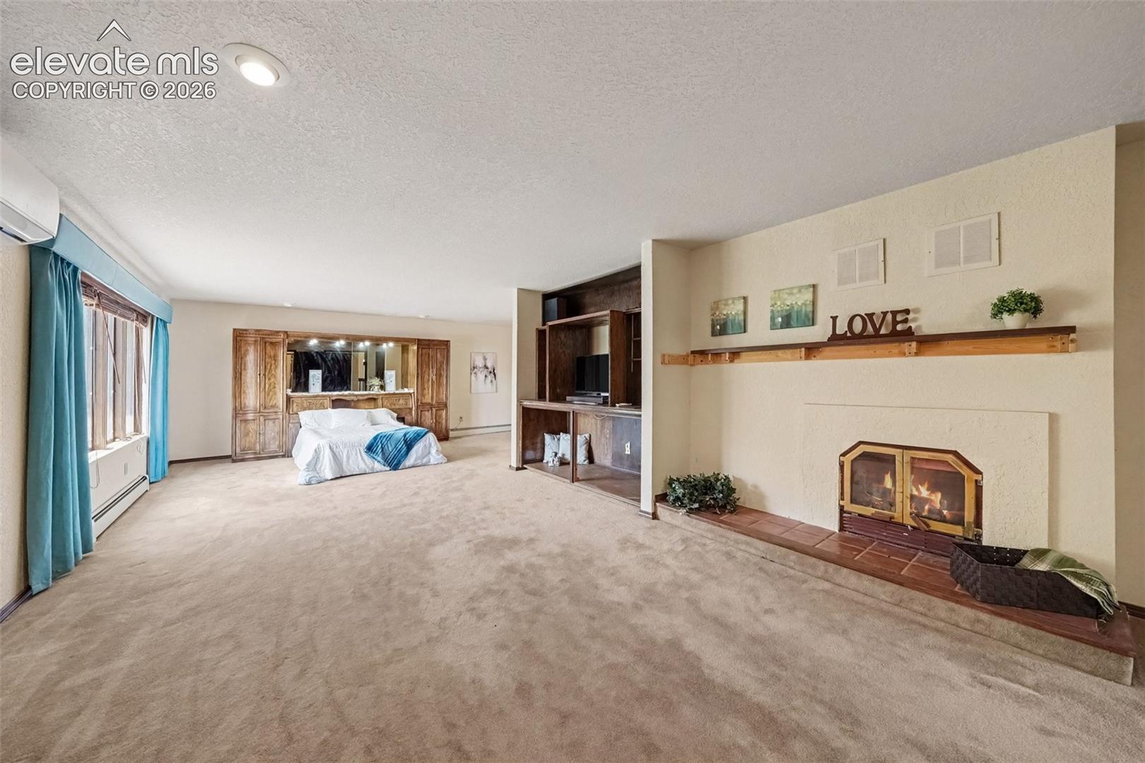 Spacious second primary bedroom upstairs features a cozy fireplace, private walkout to the stained covered deck