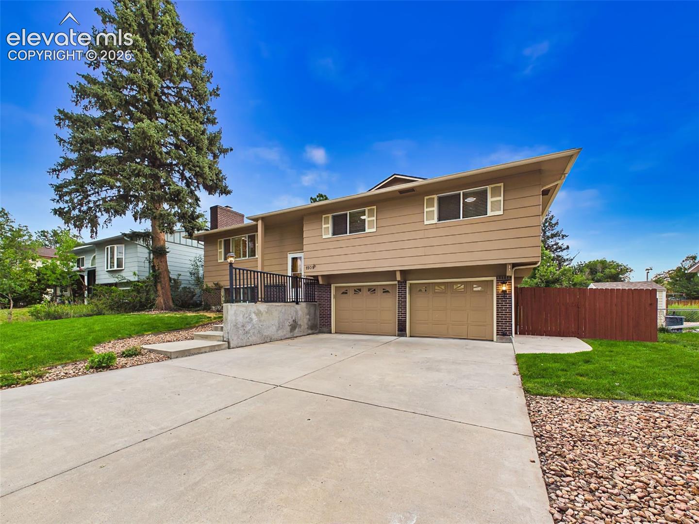 Well-maintained split-level home featuring attractive curb appeal, an oversized driveway, mature landscaping, and an attached two-car garage.