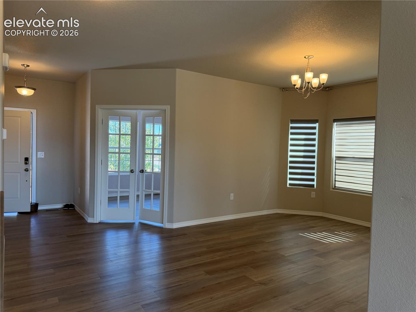 Wood-finish flooring throughout, complemented by a contemporary chandelier