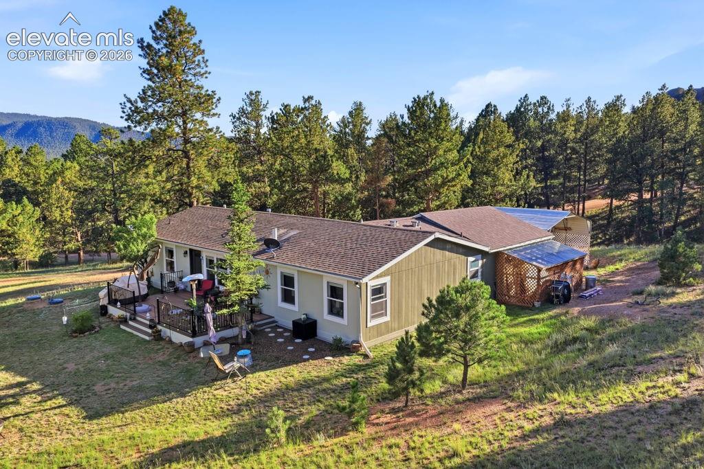 Single-story residence featuring a composite roof, light green siding, and an attached wood deck