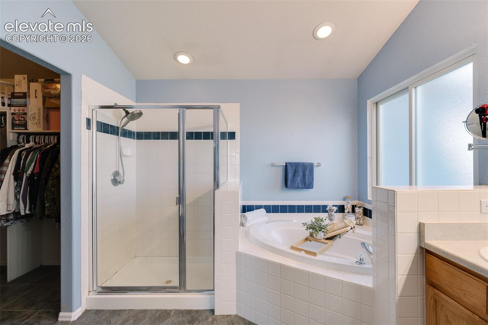 The Primary Bathroom offers a dual sink vanity, soaking tub, and separate tiled shower.