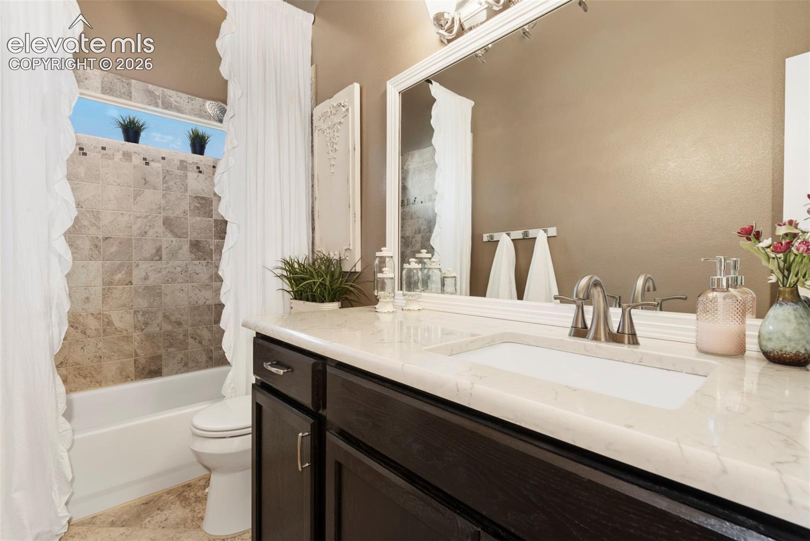 Main Level Hall Bath, High Ceiling with Raised Sink Cabinets with Natural Stone Countertop, Tiled Flooring and Tiled Tub/Shower Area