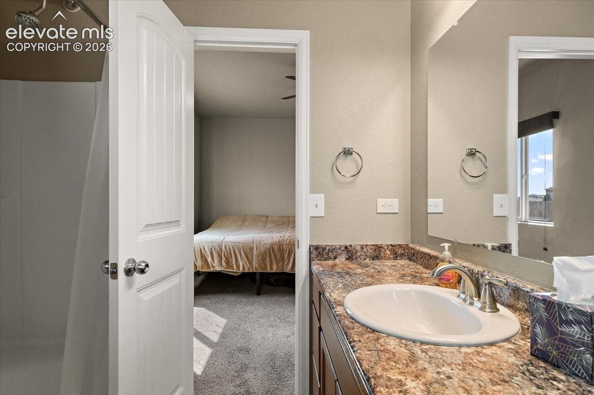 Bathroom vanity with an integrated sink, brushed nickel faucet, and a large mirror