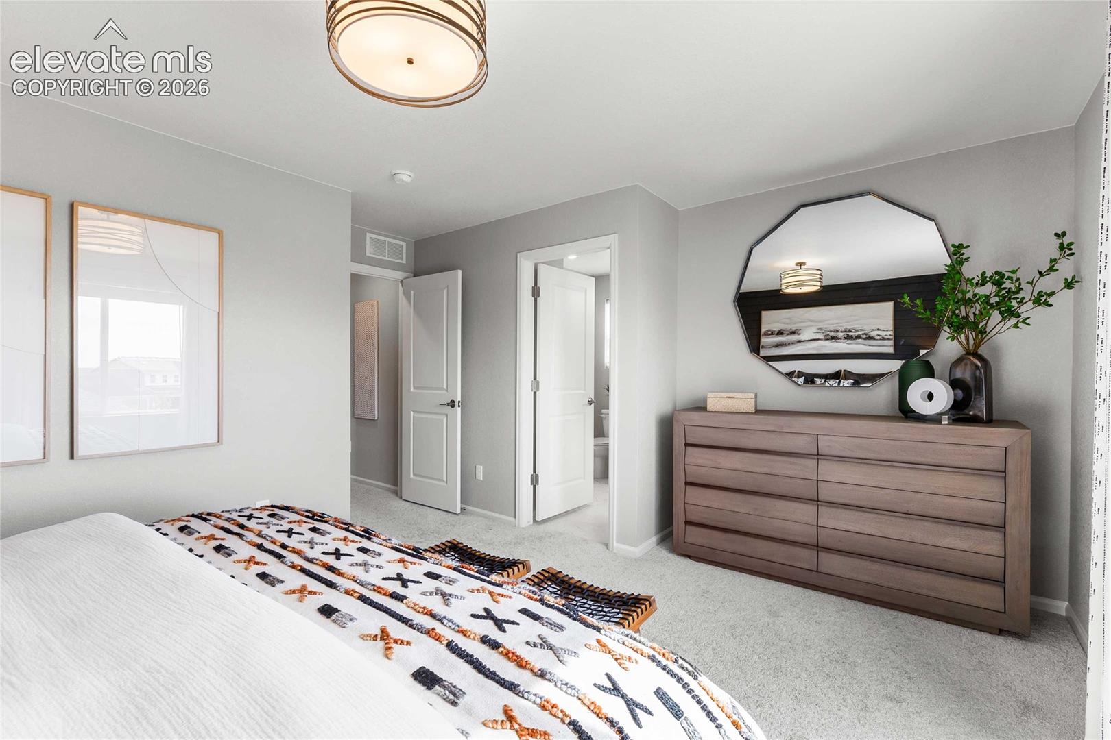 Spacious primary bedroom featuring neutral wall finishes, engineered wood-finish flooring, and abundant natural light from multiple windows
*photos of a model home*