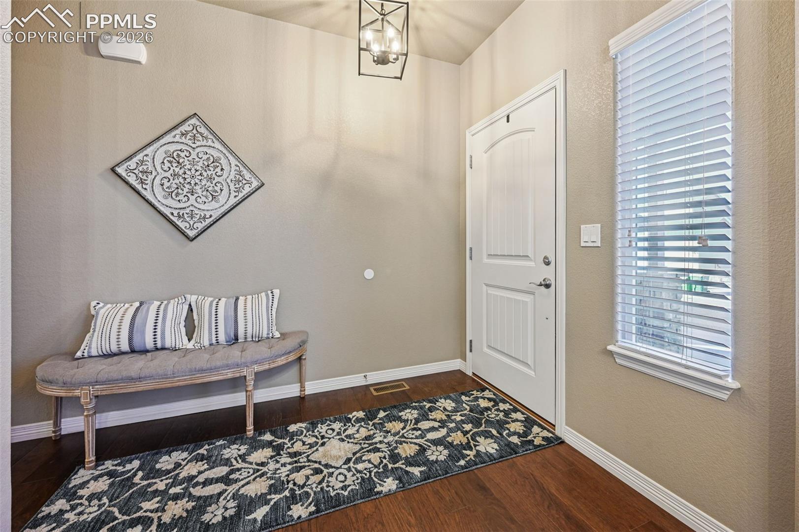Entrance foyer featuring a chandelier and dark wood-style flooring