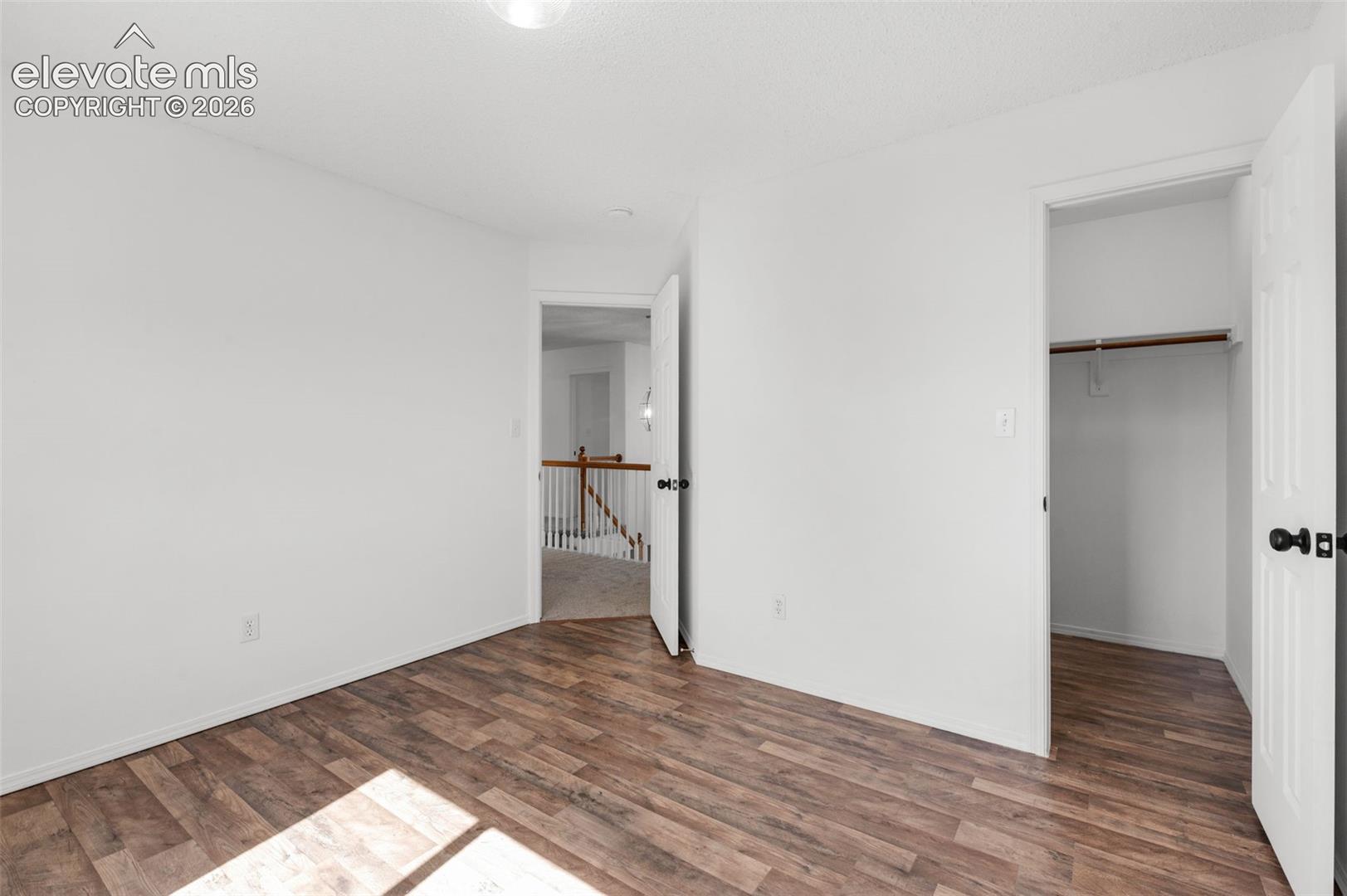 Wood-finish flooring with white walls and trim