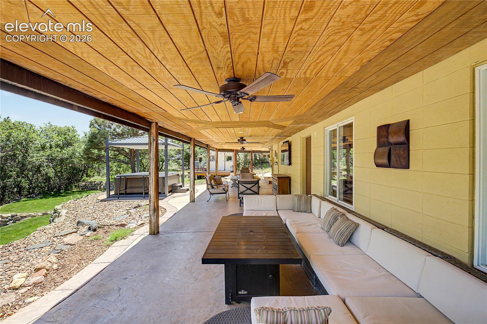 Step outside to the covered back patio, where a beamed ceiling and ceiling fans extend the home's living space well into the warmer months.