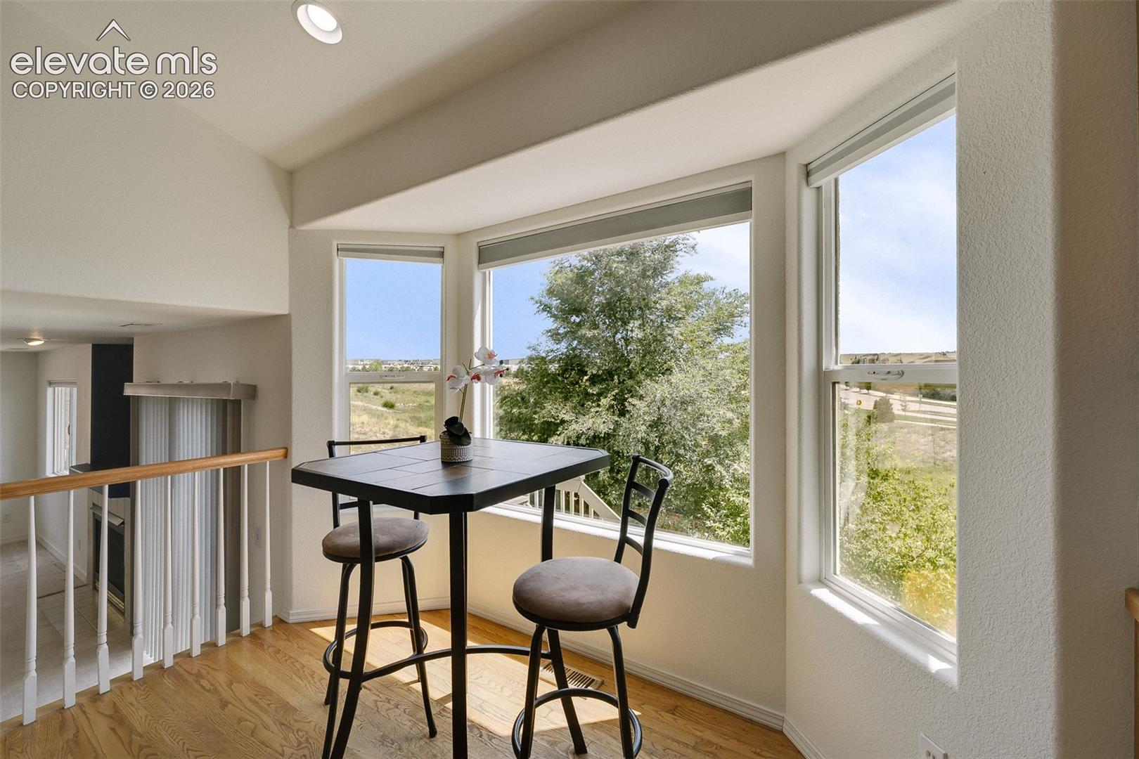 Bay window featuring multiple large panes, hardwood flooring, and a recessed ceiling light