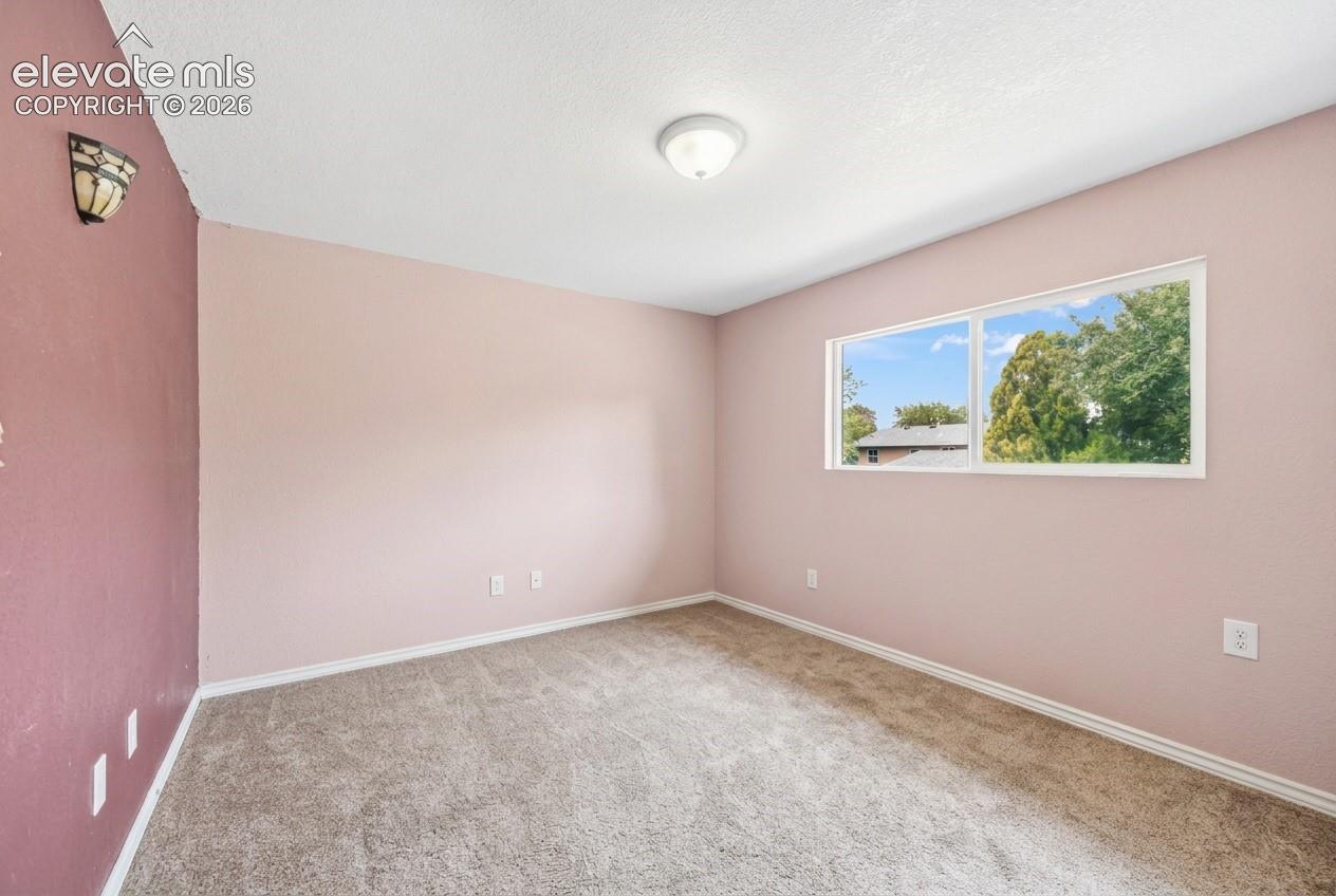 Recessed window with exterior scenery, overhead flush-mount lighting, and wall-mounted sconce