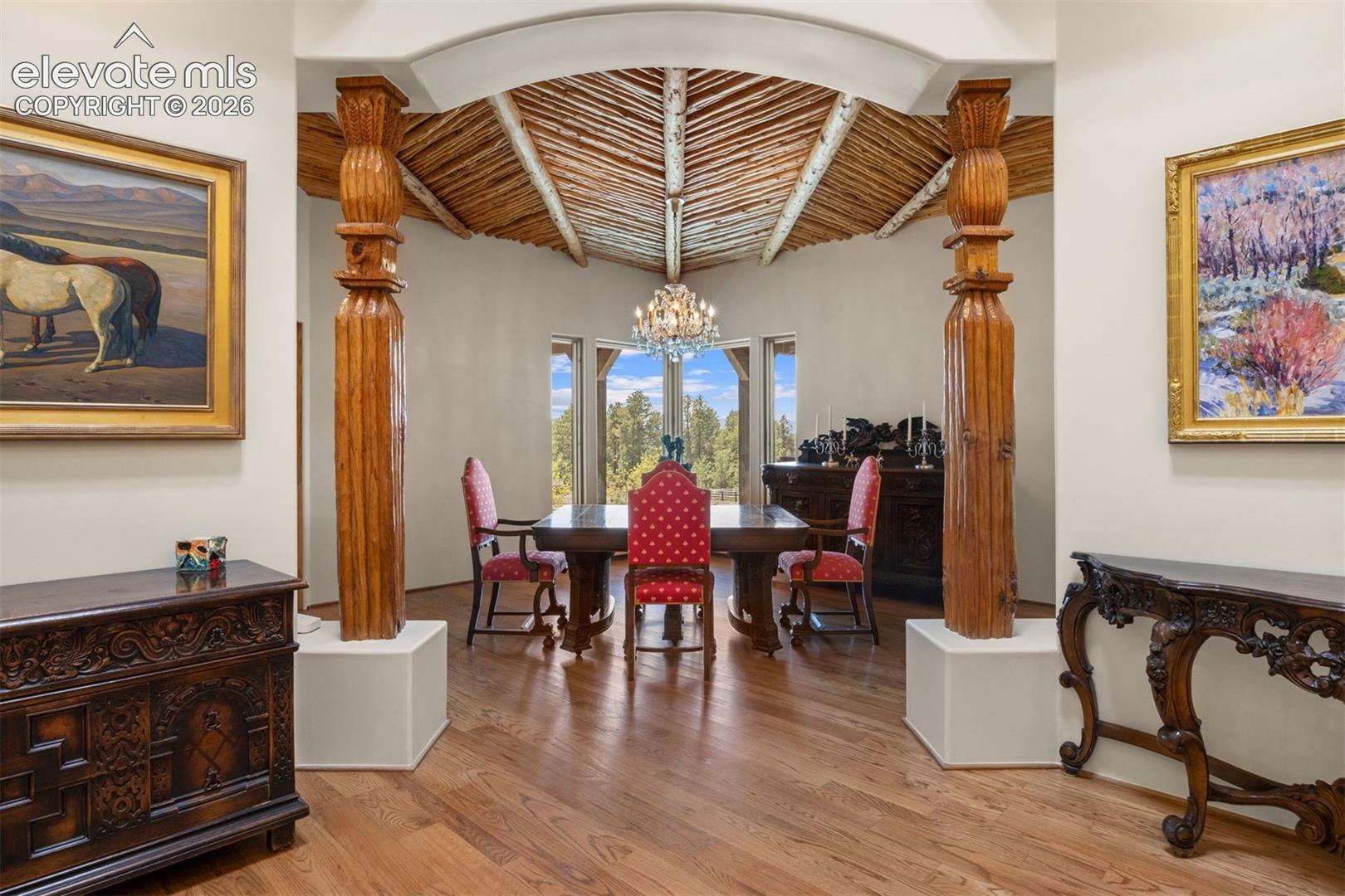 Stunning hand-carved wood columns and a sweeping archway create a dramatic transition from the foyer into the dining room. 