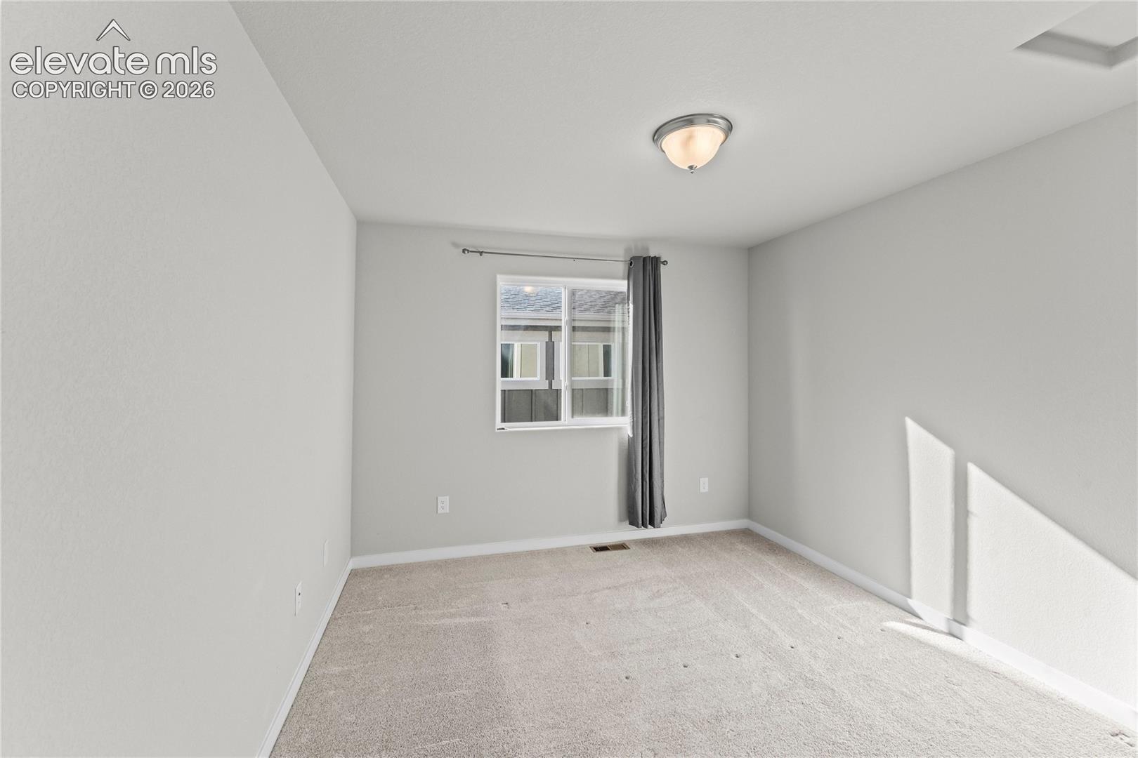 Carpeted flooring, single window, flush-mount ceiling light fixture, neutral wall paint
