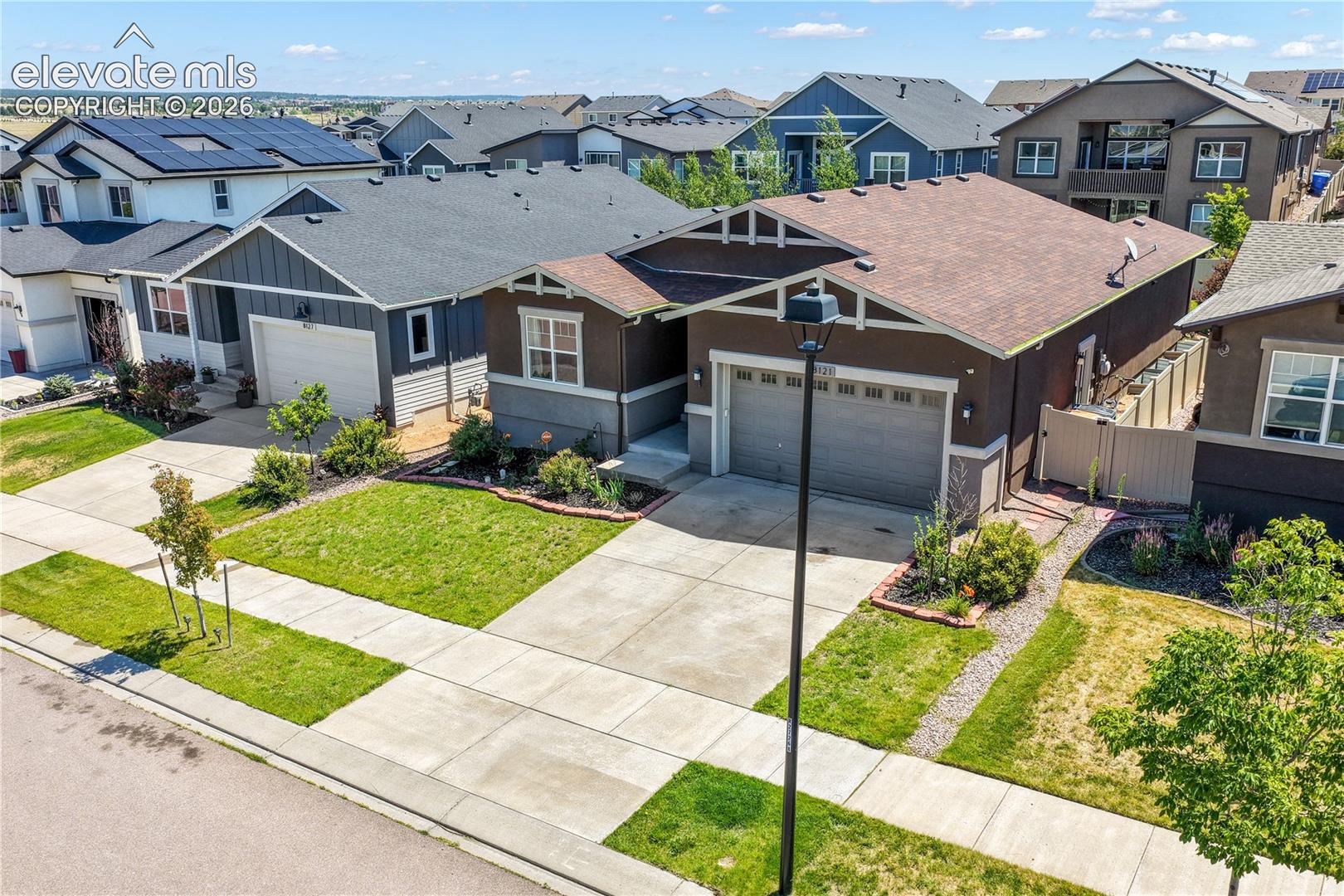 Front aerial view showing landscaping and 2 car garage
