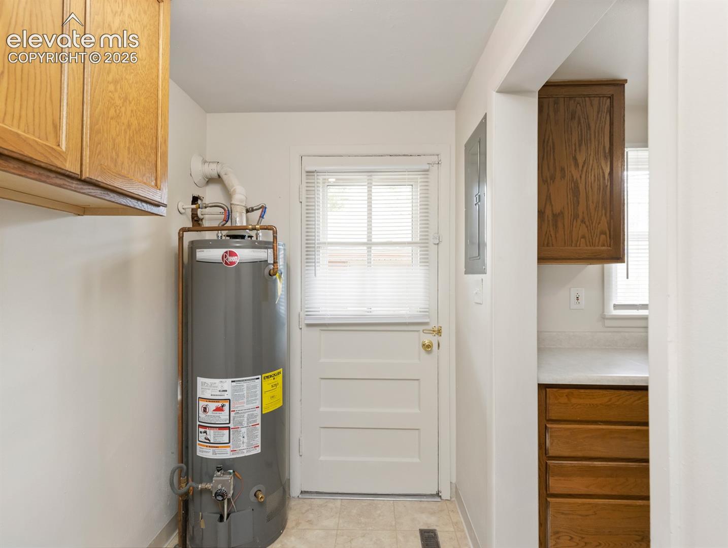 Additional view of laundry room, newer water heater, back door to storage shed