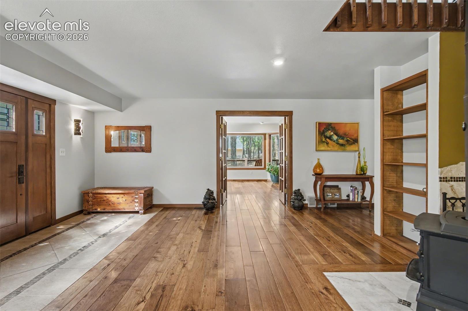 View of main entry facing entry into the office space/formal dining, and kitchen area