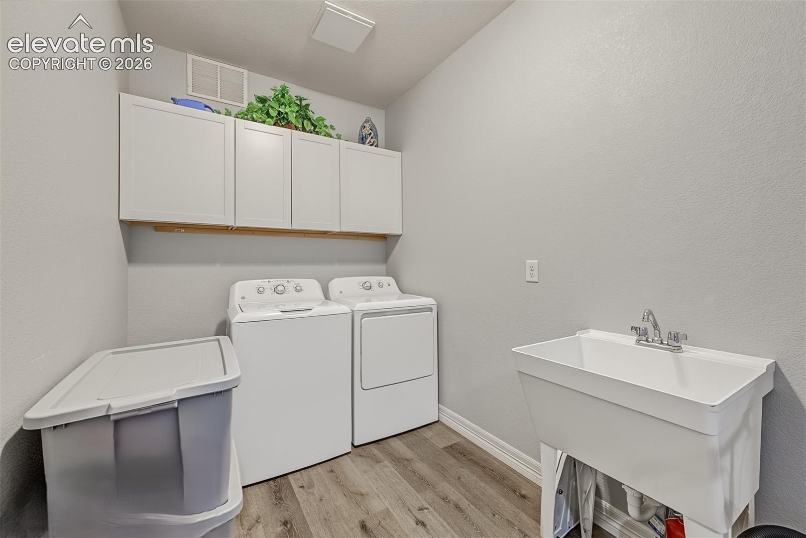 Oversized laundry room includes new washer/dryer, utility sink, extra cabinets, garage access and a pocket door for added privacy from the main living area.