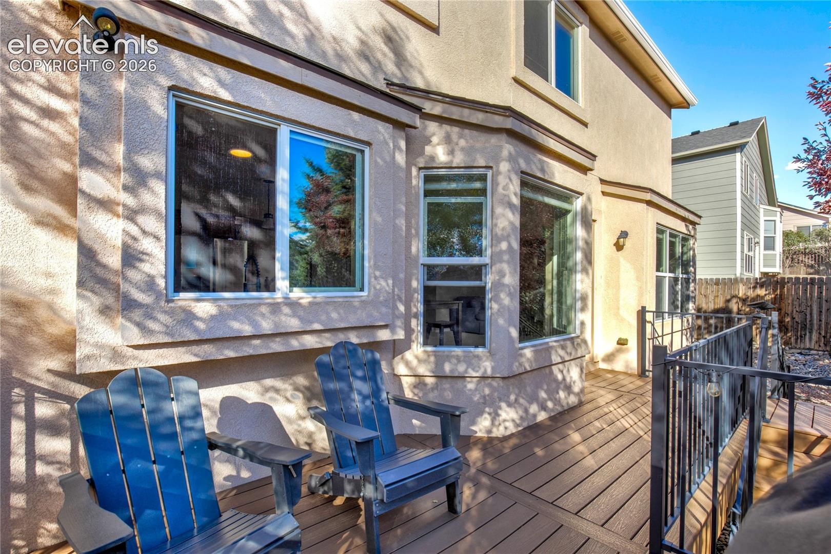 Step outside from the dining area onto the elevated deck, where comfortable seating, attractive railings + backyard views extend the home's entertaining space outdoors.