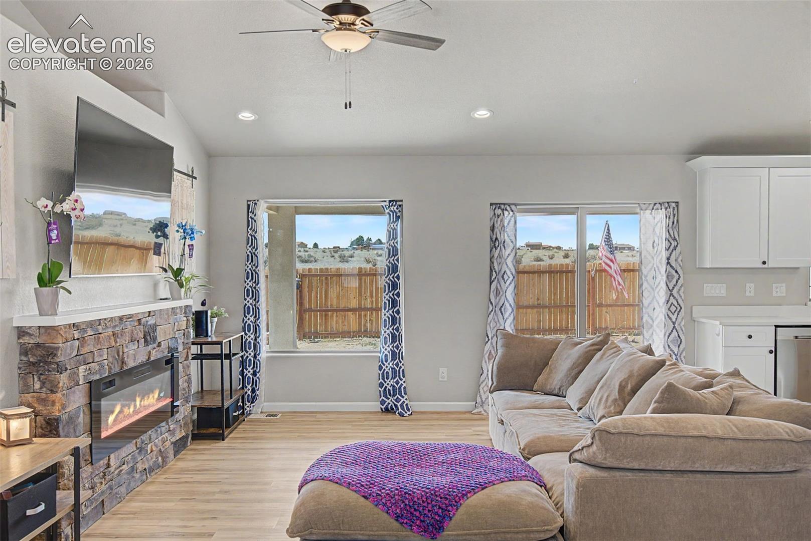 Open-concept living area with vaulted ceilings, recessed lighting, and wood-finish flooring