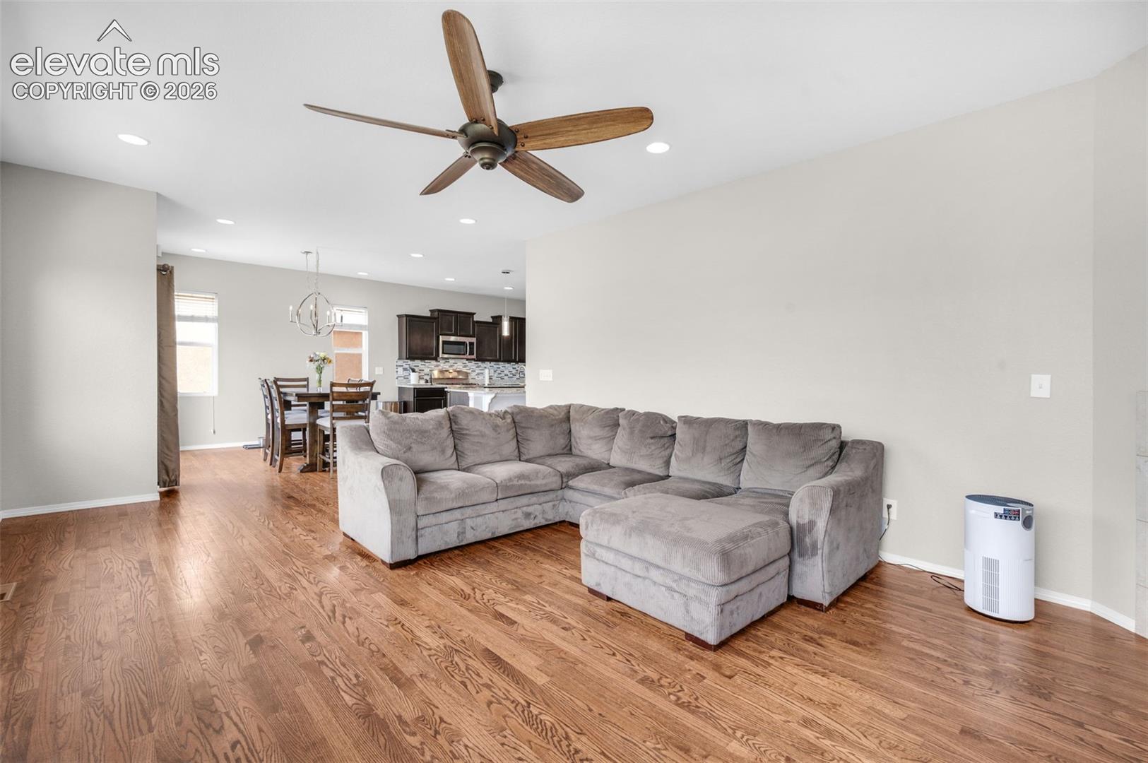 Expansive living area featuring wood-finish flooring, recessed lighting, and a ceiling fan