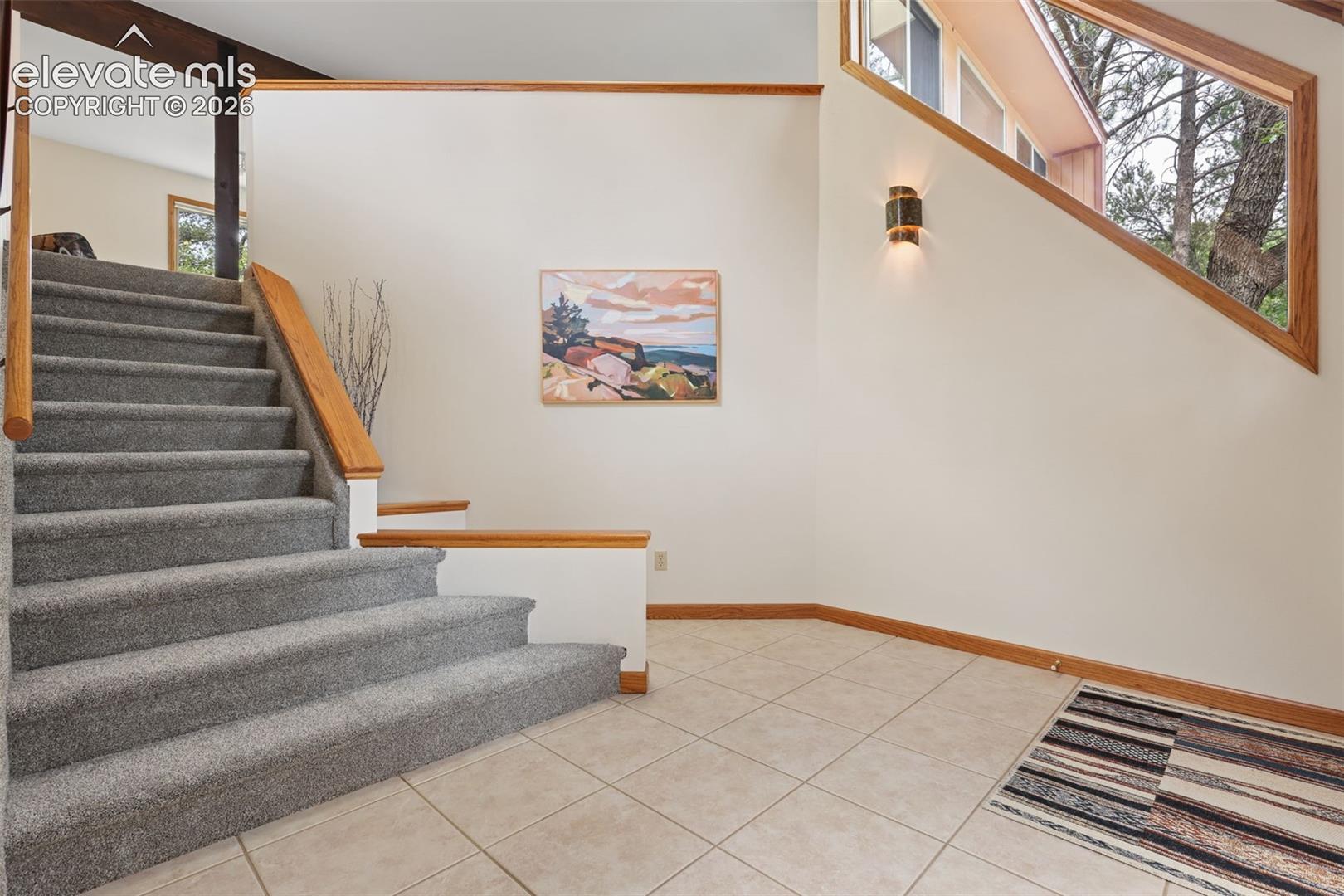 The sweeping staircase takes you to the open concept living room, dining room, and kitchen.