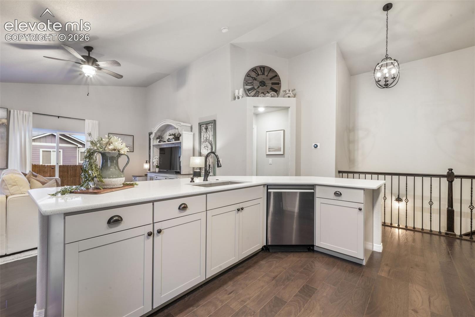 Kitchen island with white cabinetry, stainless steel dishwasher, and a single-basin sink with a gooseneck faucet