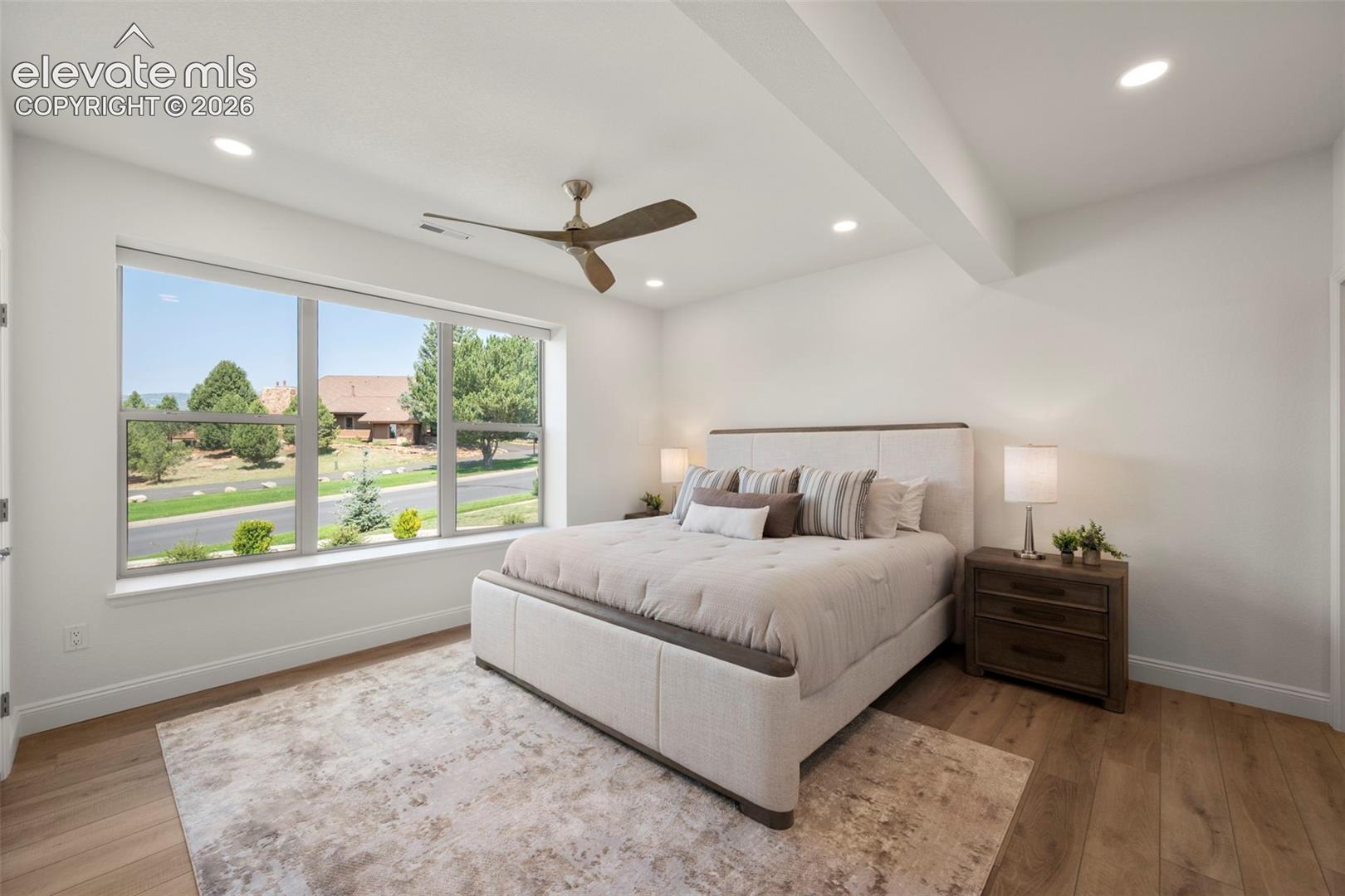 Expansive window offering abundant natural light, recessed lighting, wood-beautiful flooring, and a ceiling fan
