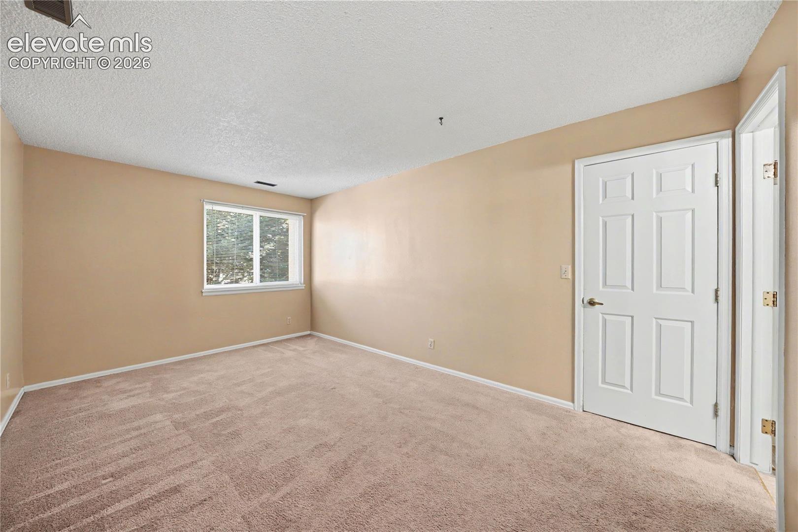Bedroom with window and carpeted floors