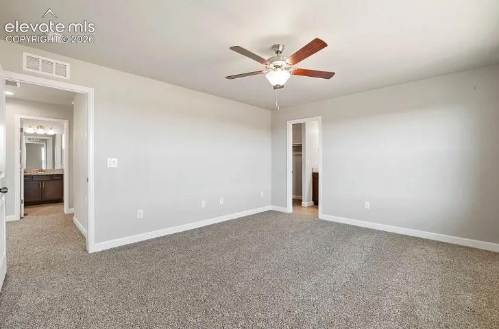 Neutral-toned carpeted flooring, multi-speed ceiling fan with integrated lighting, and painted walls