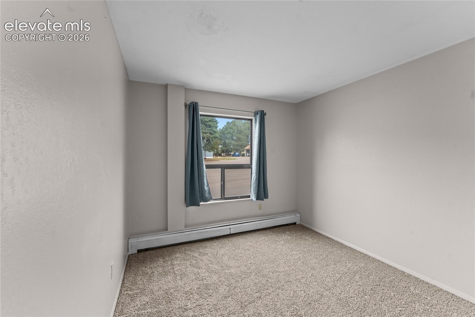 Room featuring neutral wall tones, wall-to-wall carpeting, and a window with exterior exposure