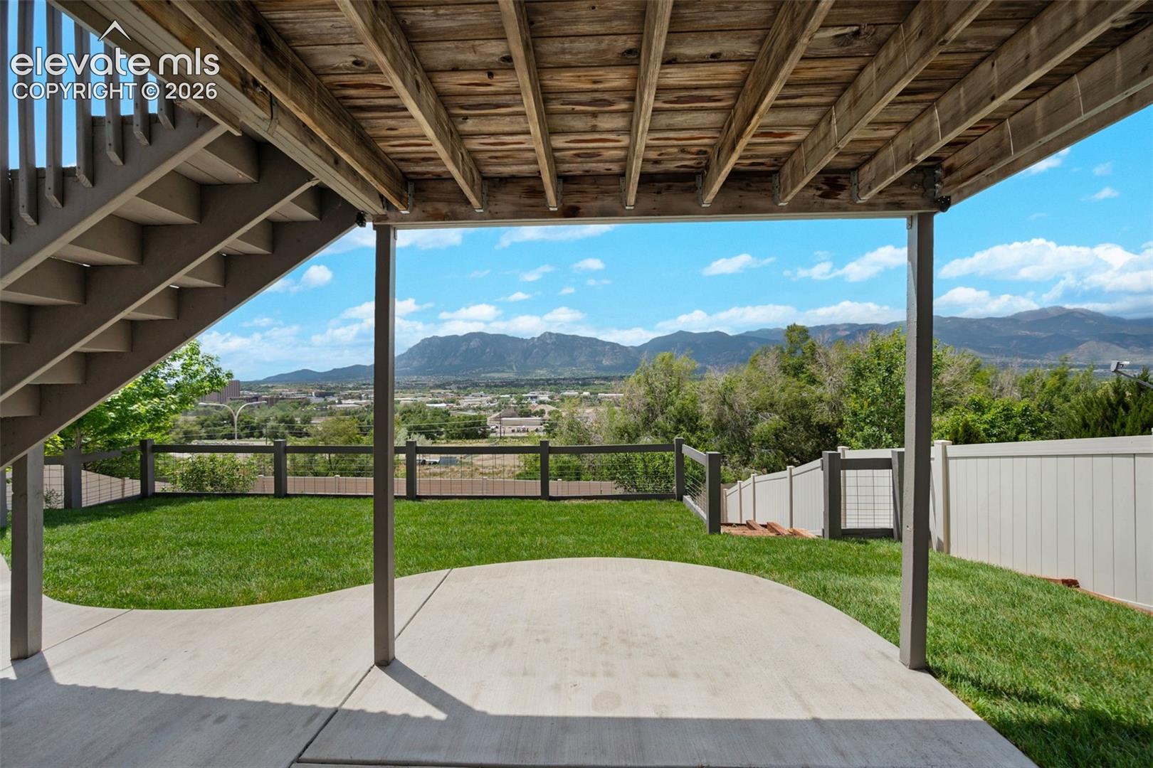 Expansive concrete patio under an elevated deck with exposed wood joists