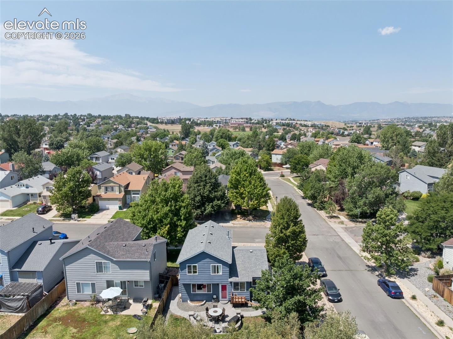 Expansive neighborhood setting with mature trees and mountain scenery