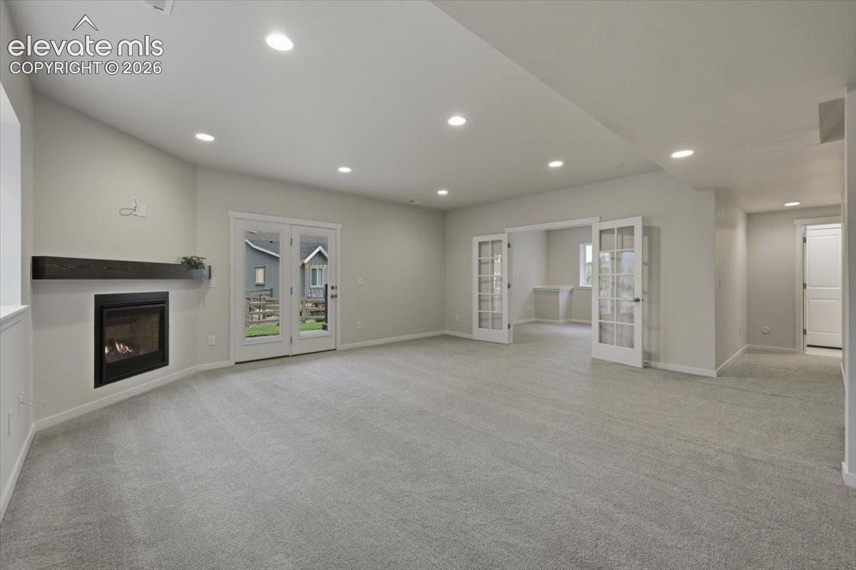 Basement family room- french doors are the 6th bedroom/flex space - hallway goes to another full bath 