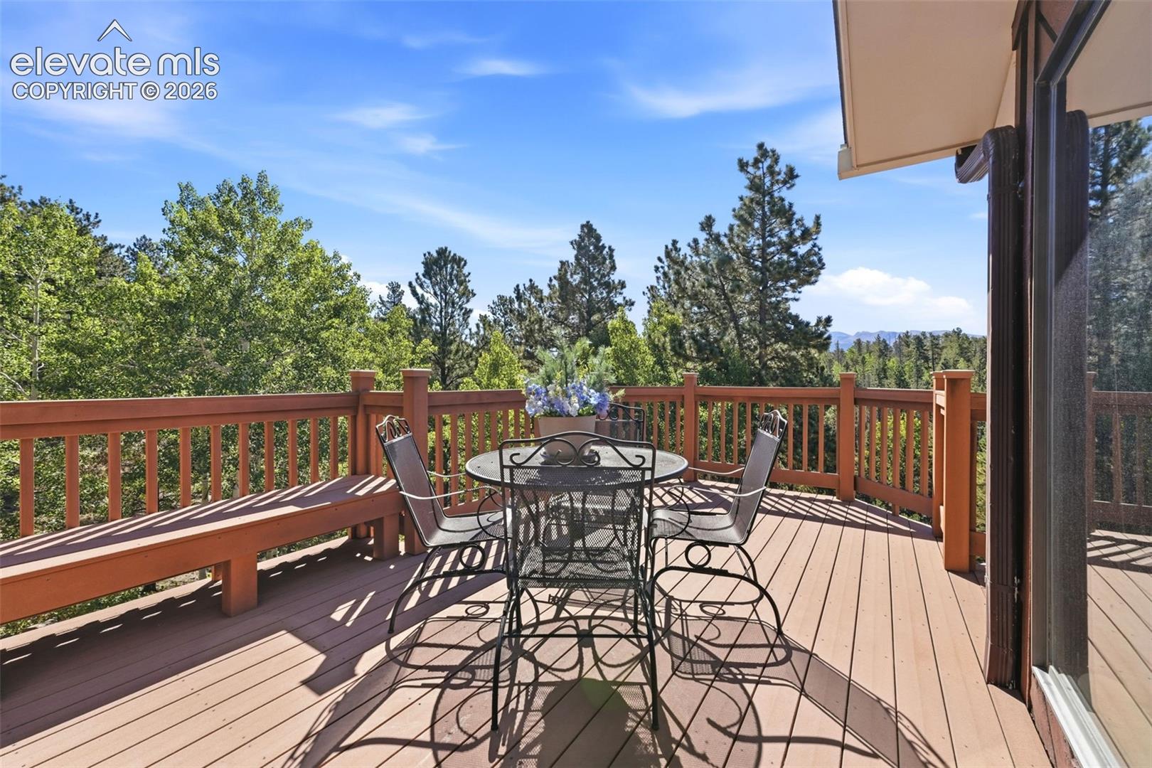 Expansive outdoor deck with wood-finish flooring and a built-in bench