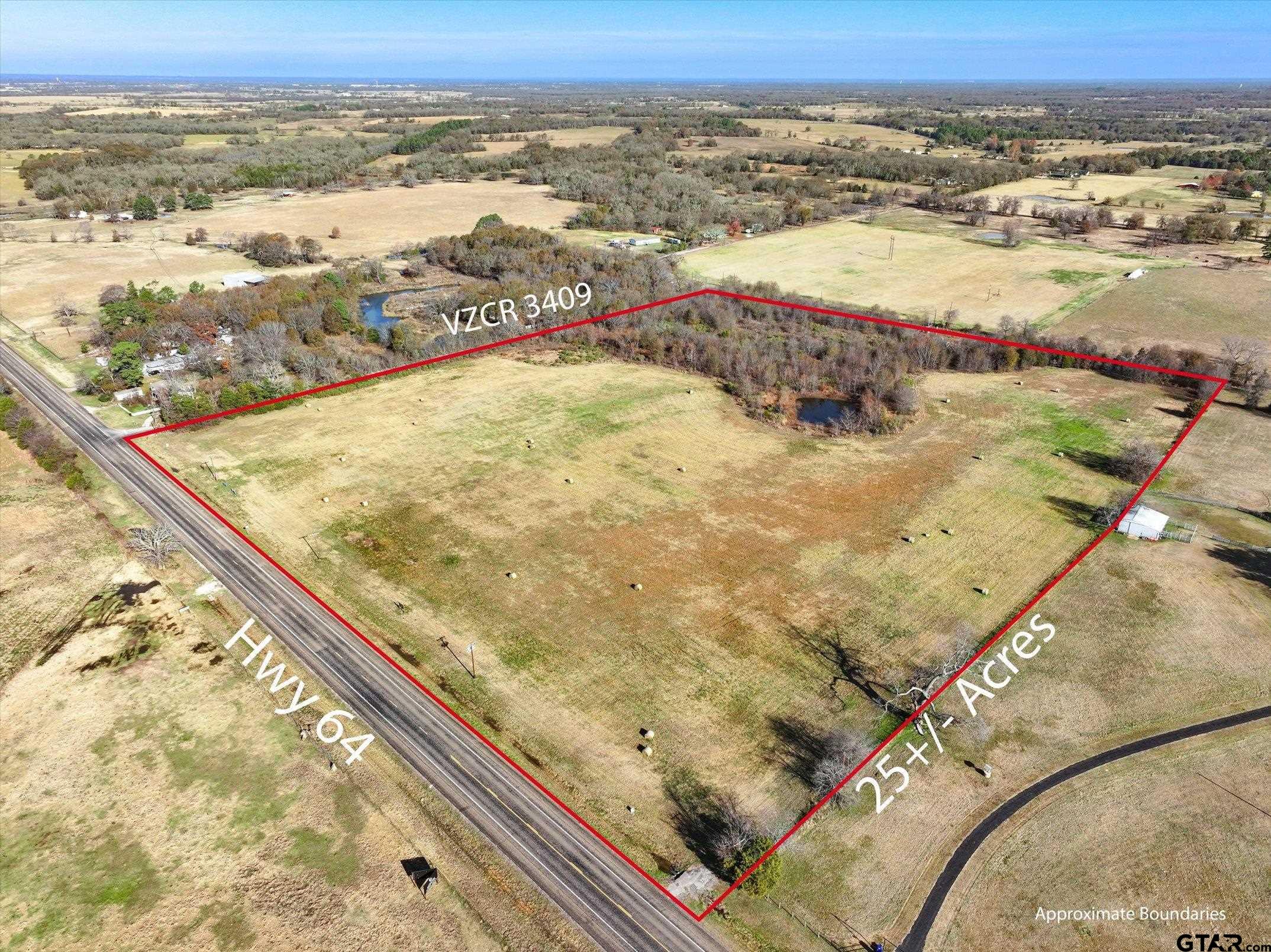Aerial view of a 25-acre pasture tract outlined in red, with wooded areas and ponds beside Hwy 64.