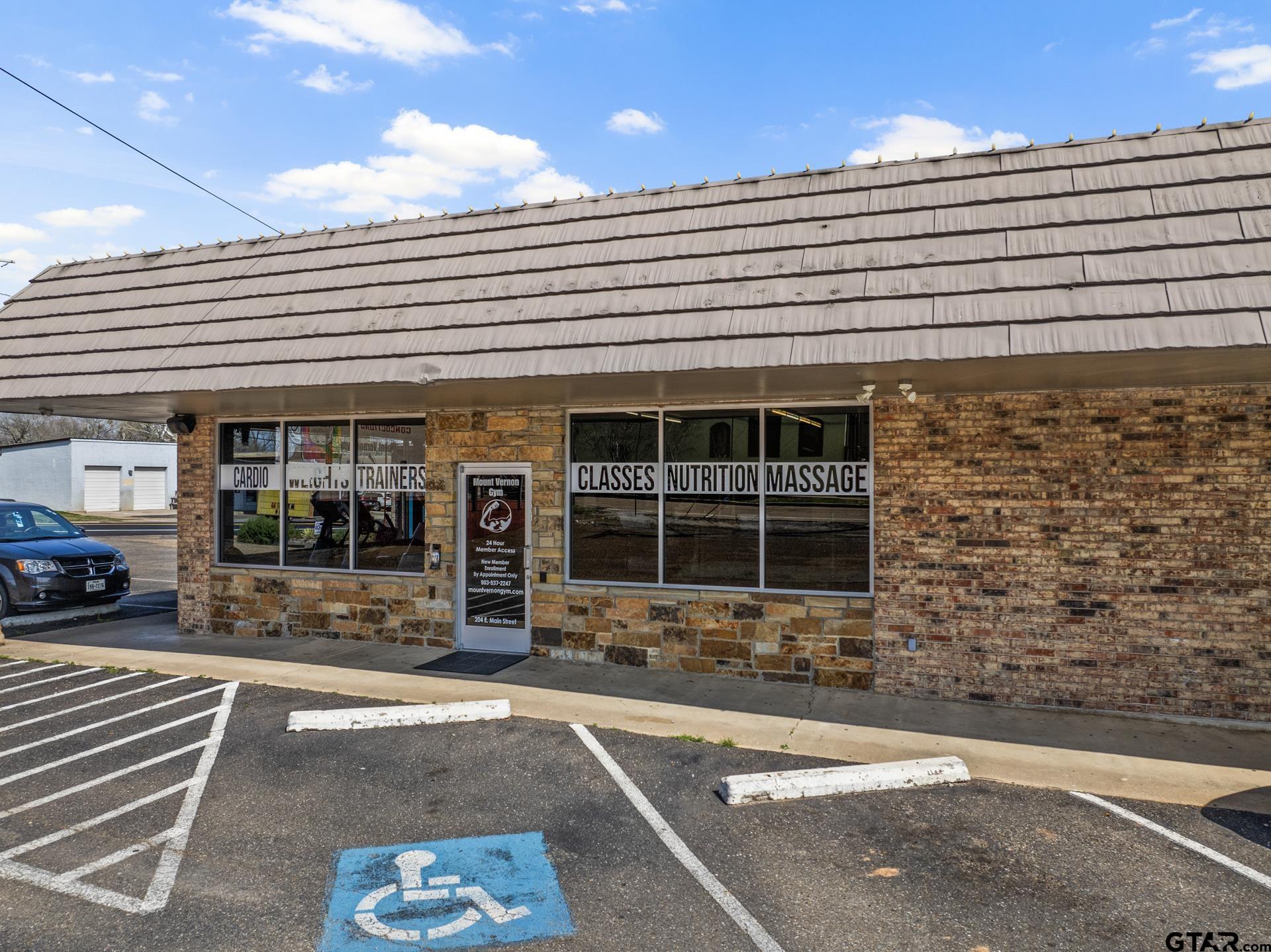 Mount Vernon Gym storefront with class and massage signs and accessible parking in front.