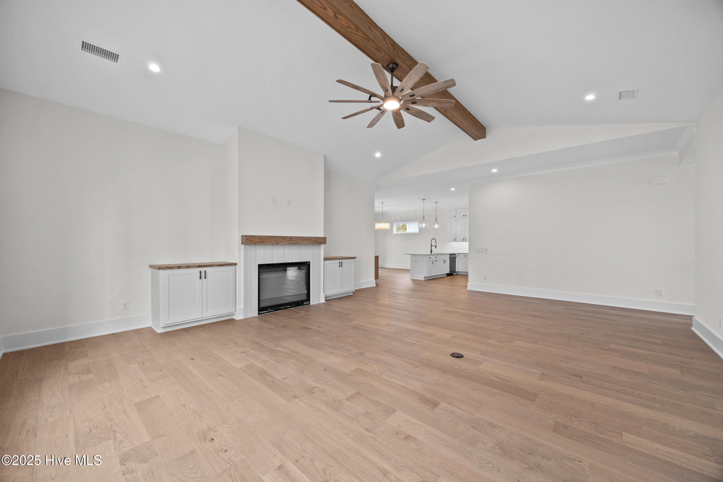 Living room with vaulted ceilings, custom built-ins, and a natural gas fire place