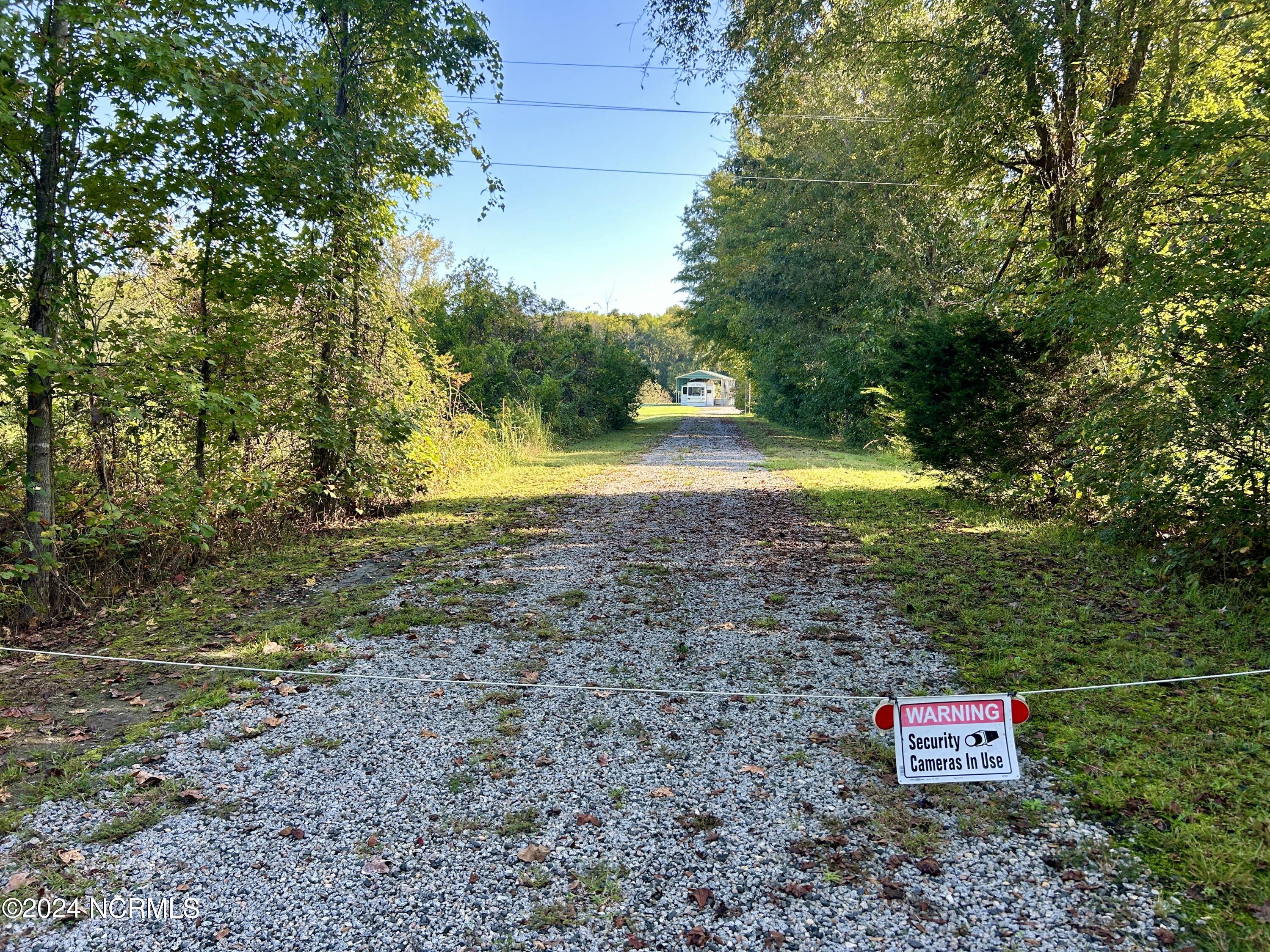 view from road to property. gate is locked and will require a key