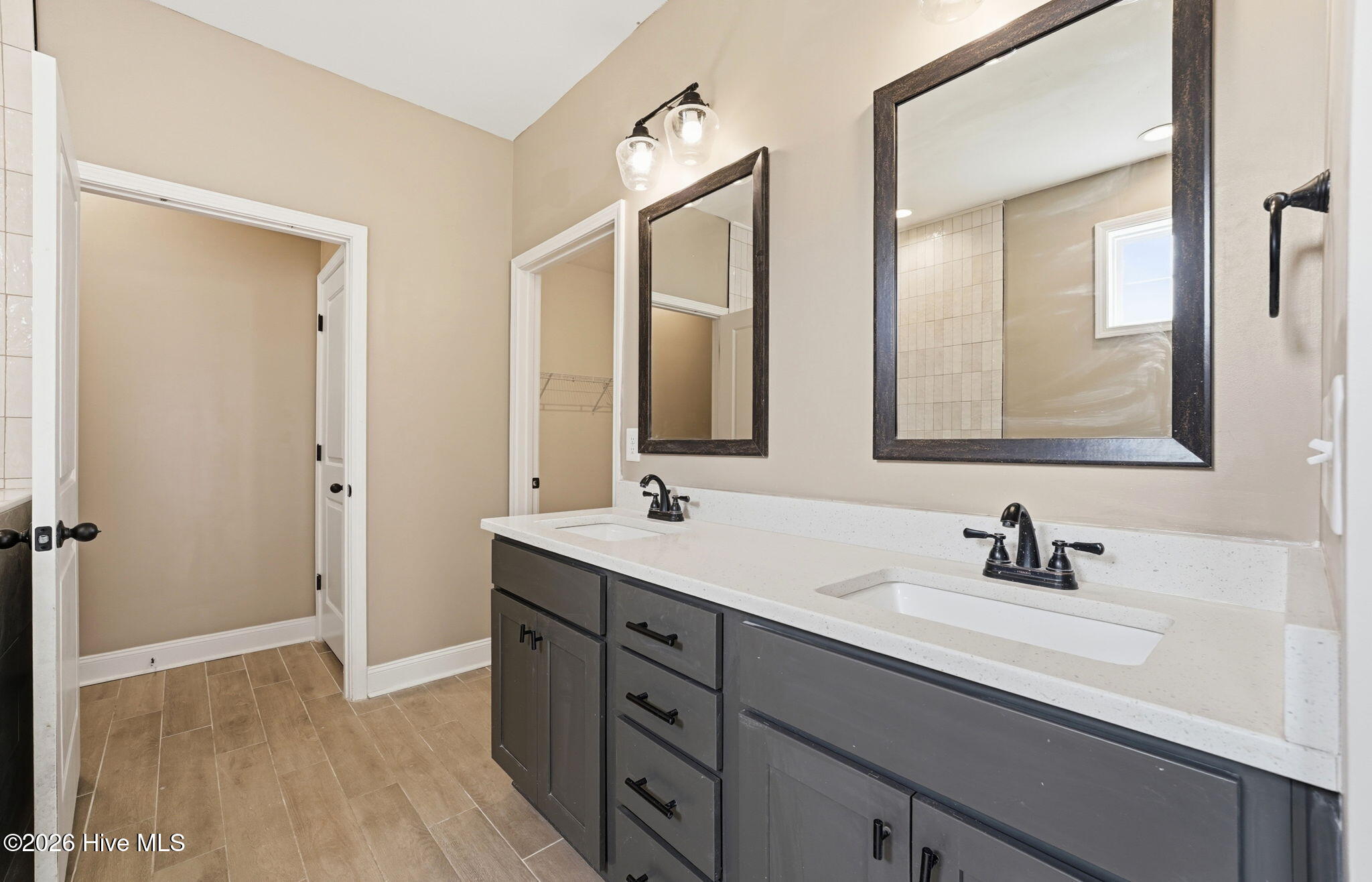 Primary bathroom offering double vanity, private commode & walk-in closet