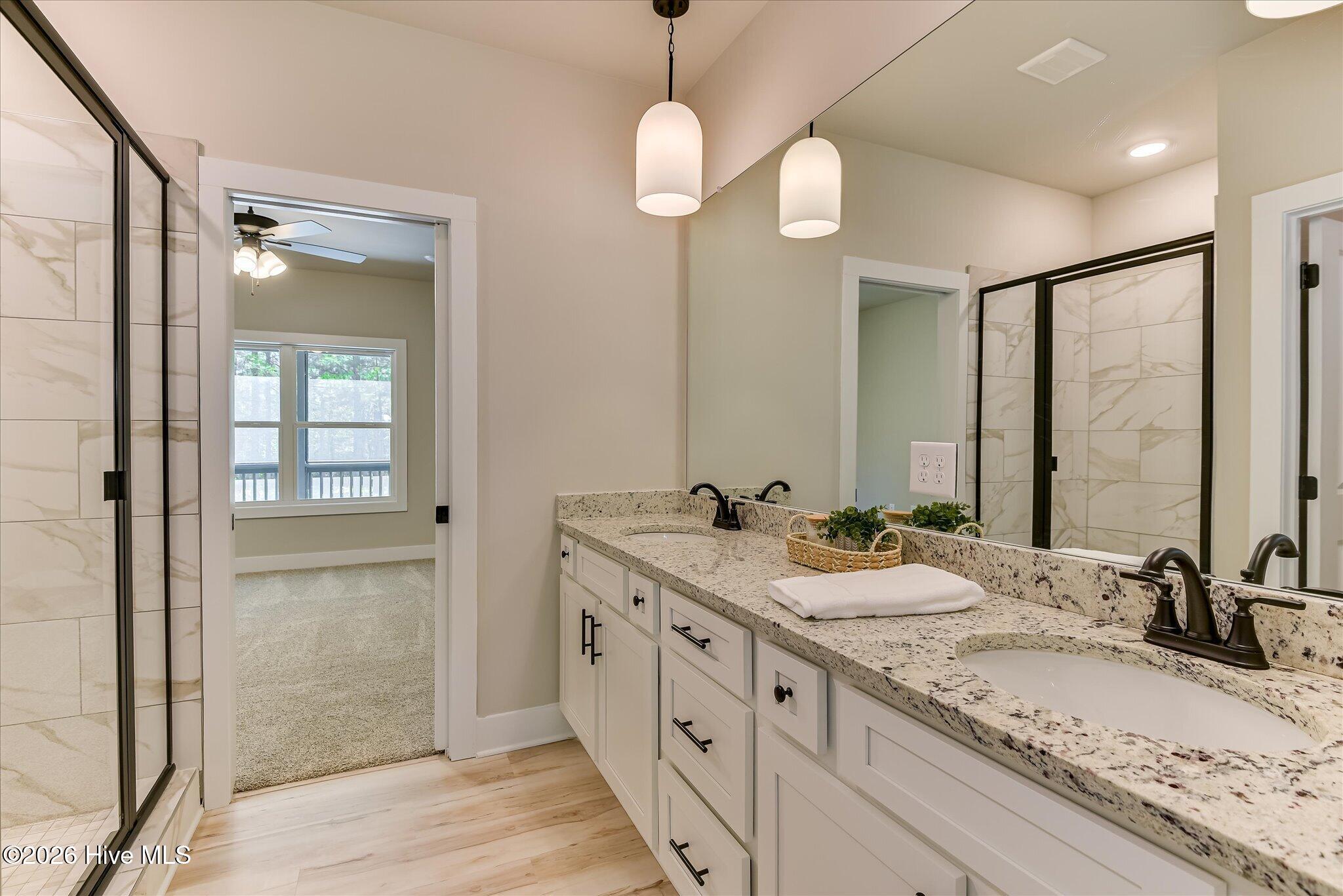 Primary Ensuite with double-sink vanity, tile shower, large walk-in closet