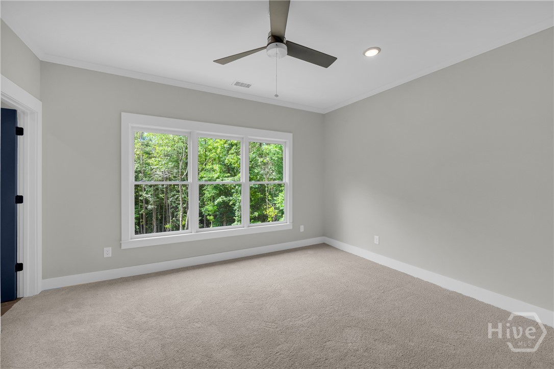 Spacious En Suite Bedroom featuring light gray walls, white trim, and light gray carpeting