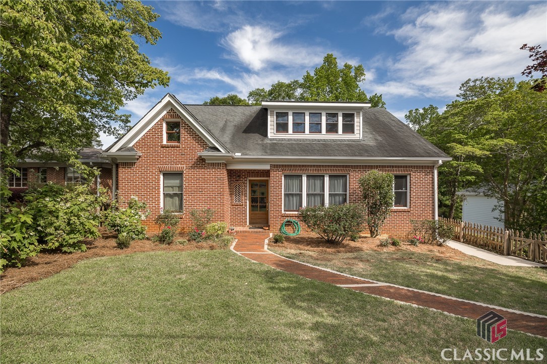 What a lovely surprise! This cozy, brick cottage boasts enormous character from the picket fence in the front yard to the beautiful stained 6 pane front door! Upon entering the home, you are welcomed by the expansive hardwood floors which are located throughout the main level! The great room and formal dining room are open to one another and feature beautiful custom maple cabinets with built in storage in the great room, as well as a gas log fireplace. The kitchen was renovated in 2021 with white quartzite countertops, custom tile backsplash as well as freshly painted kitchen cabinetry. There is an abundance of storage with three walls of cabinetry and great counter space. A multi-season, vaulted screened porch is located off the side of the home and offers a great place for outdoor dining or coffee drinking. A small mud room is located off of the access door which serves as an every day “drop all”. Completing the main level are two bedrooms and two full baths, one of which is the master suite. The master bedroom is serviced by two closets, and the bathroom is fully tiled with radiant heat floors and a double tile shower. The second main level bedroom utilizes the main hall bath, and offers great potential as space to enlarge the current master bath and create a separate home office if so desired! A gorgeous open stairwell leads you to the upper level featuring heart pine floors in the oversized flex space and hallway! Numerous windows flood this space with natural light, and provide a gorgeous view of the rear yard. Upstairs consists of three bedrooms which share a full hall bathroom, with ample space to add an additional bath if so desired. The basement has an additional large (6th) bedroom, renovated full bath, cedar storage closet, and plenty of storage/workshop space with exterior access. This spacious, level lot has a fully fenced yard with a wonderful grassy area, as well as a more natural section shaded by trees for play equipment or a fire pit. Walk to Barrow Elementary, Memorial Park, Sanford Stadium and all of the wonderful retail and dining that Five Points has to offer. In-town living at its finest! Last, but not least, the 1 bedroom/1 bath basement area has been rented as an Air B’nB with great income potential! Contact listing agent for further information.--