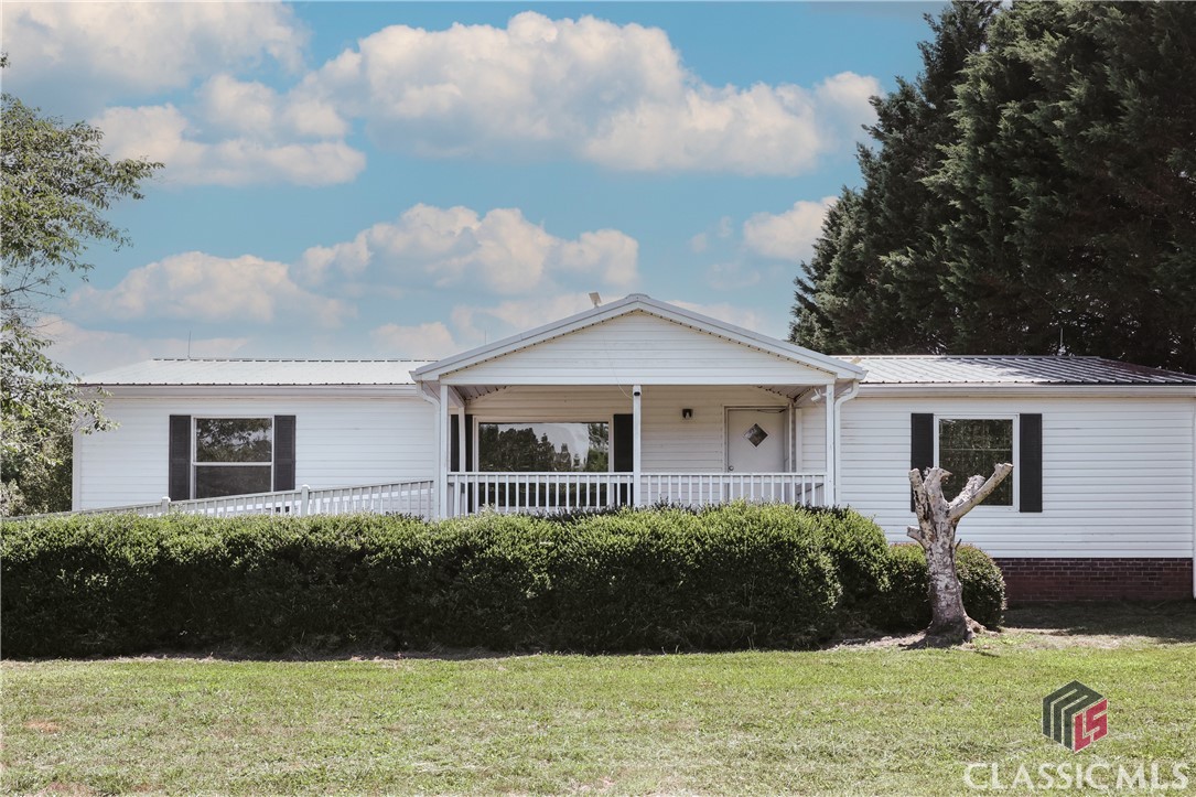 Wonderful 3/2 manufactured home for sale! Sitting on a picturesque 5 acre lot, this house is perfect for anyone looking for an affordable home and a large lot to spread. Small details set this one apart. A pretty driveway takes you into the property taking you by a serene pond. The house has been completely painted in the interior giving it a fresh & light palette that bounces the natural light. Vaulted ceilings in the living room make it feel spacious and inviting. All doors are handicap accessible. A two car attached garage was added to the house. This home has been meticulously taken care of. Newer systems and a metal roof guarantee a long enjoyment without the worry of replacement costs.  Easy commute to Athens and less than 10 minutes away from Winterville!Make a showing appointment today!