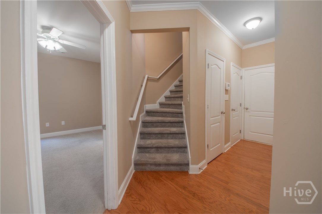 Hallway to Secondary Suite, Stairs to Bonus Room and Basement and Hall to Garage and Storage Closets