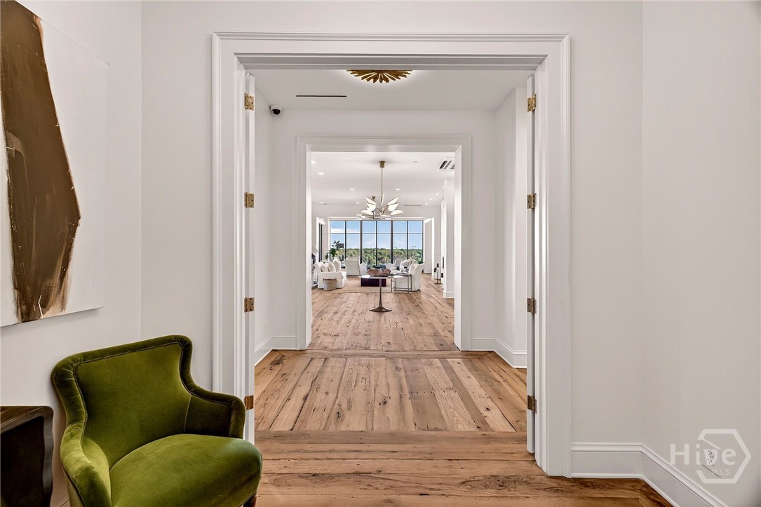 Foyer - An inviting corridor framed by double doors leads to a bright, open living space with stunning natural light and expansive views.