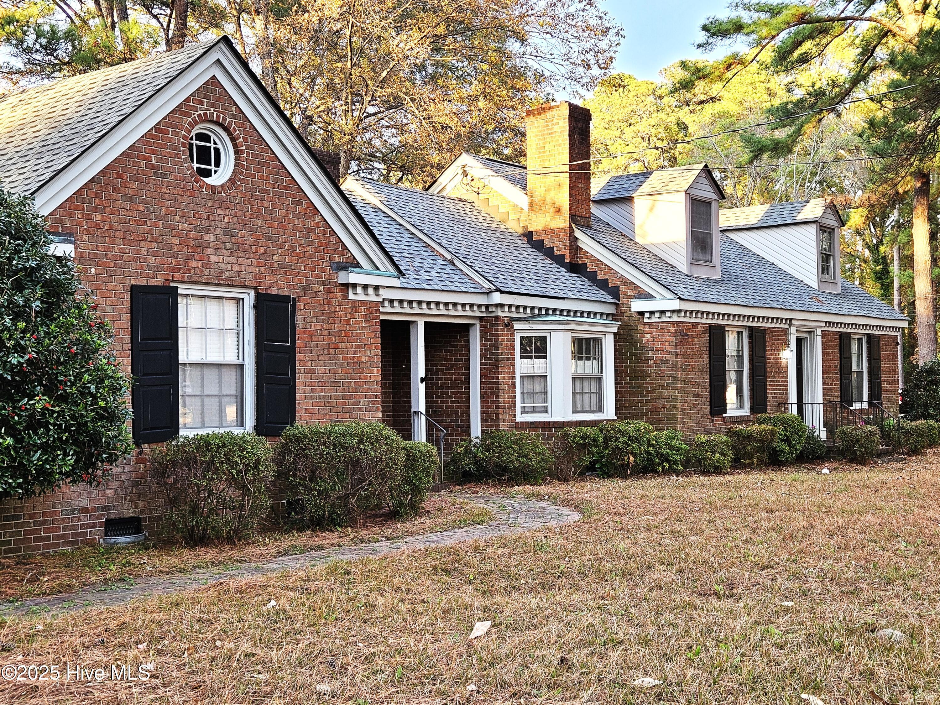 More photos coming soon.  LOCATION! Walking distance to downtown, The Mill, Farmer's Market.  Two lots being sold together make almost one acre -- unusually large lot so close to downtown.  Own your own block -- one side of the street on the 200 block of Wilkinson Street!  Finally, the quiet privacy you want close to city amenities.  Spacious, well-built brick home nestled on a beautiful wooded lot.  Most of living space is on first floor with bonus room and walk-in attic on second floor.  First floor has a split floor plan with primary bedroom suite on one end of home and other bedrooms and bath on far end of home.  In the middle you will find a den/office, large kitchen, dining room, and living room.  All hardwood floors.  Large heated and cooled sunroom with newer Anderson windows overlooking back yard.  Floorplan could accommodate in-law suite -- master suite and den adjacent to kitchen with its own front entrance and its own door to sunroom.  The rest of the home including stairs to bonus room are on the other side of kitchen with front entrance and its own entrance to the sunroom.  Laundry room is located just off the sunroom.  Covered brick patio off sunroom leading to carport.  Roof is 3 years old.  HVAC for downstairs is 7 years old.  Split unit for bonus room is 8 years old. New sewer line. Outdoor workshop with two sections is wired and provides lots of storage.  Lean-to shed attached to workshop for extra storage.  Classic mid-century brick home in beautiful and peaceful setting with so much space indoors and outdoors.  This just might be the one -- don't let it go!  Set up your no obligation appointment today to see if this is a fit.