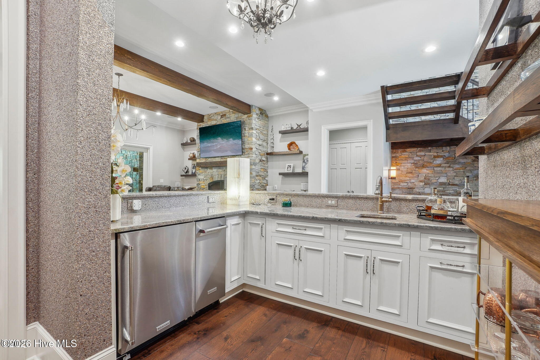Main level bourbon wet bar with ice maker refrigerator and glass wine cellar with remote split syste