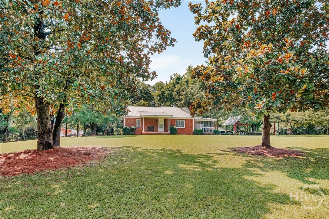 Open House Saturday, August 15th 1-3pm! This charming four-side brick home sited on just over 1.5 acres is perfect for having a little more room to roam but not being far from town. Start a vegetable garden, care for some extra critters, and enjoy all the outdoor entertainment space like the huge screened porch or the gazebo and patio. Not to mention the hot tub! Inside, the home still has its charm but with thoughtful updates like refinished hardwood flooring and a remodeled bathroom on the main level. The basement level could be utilized as an income suite and features a full bathroom, two bedrooms, and new LVP flooring. Other bonuses include a lifetime metal roof, detached carport with workshop/ electricity, a fenced area for pets, and two lovely magnolia trees in the front yard. Call to see this charmer today!